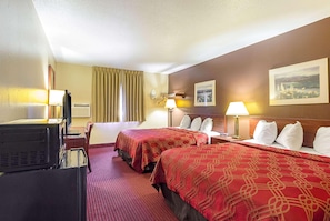 A hotel room with two beds, a TV, a desk, and a lamp. - Americas Best Value Inn Fargo (Fargo)