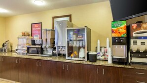 A hotel kitchen with a coffee station, a refrigerator, a microwave, and a coffee machine. - Americas Best Value Inn Fargo (Fargo)