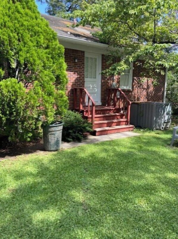 Stroll up to the charming brick house with a cozy front porch and beautifully manicured lawn.