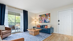 Un salon avec un canapé, une table basse et un tableau au mur.