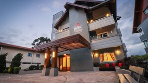A hotel with a modern design, featuring a covered entrance, outdoor seating, and a well-lit facade. - Pousada Bella Viena (Gramado)