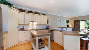 Enjoy cooking in this well-equipped kitchen with a central island, stove, and modern sink.