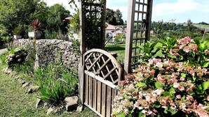 A garden with a wooden gate, a stone wall, and a pergola structure. - Burusenia - Hasparren (HASPARREN)