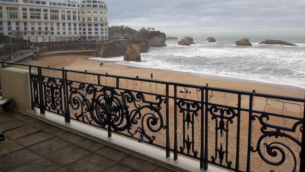 A balcony with ornate black metal railings overlooking a beach with rocky formations and waves. - Burusenia - Hasparren (HASPARREN)