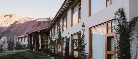 Un edificio moderno con amplios ventanales y un camino de piedra que conduce a la entrada.