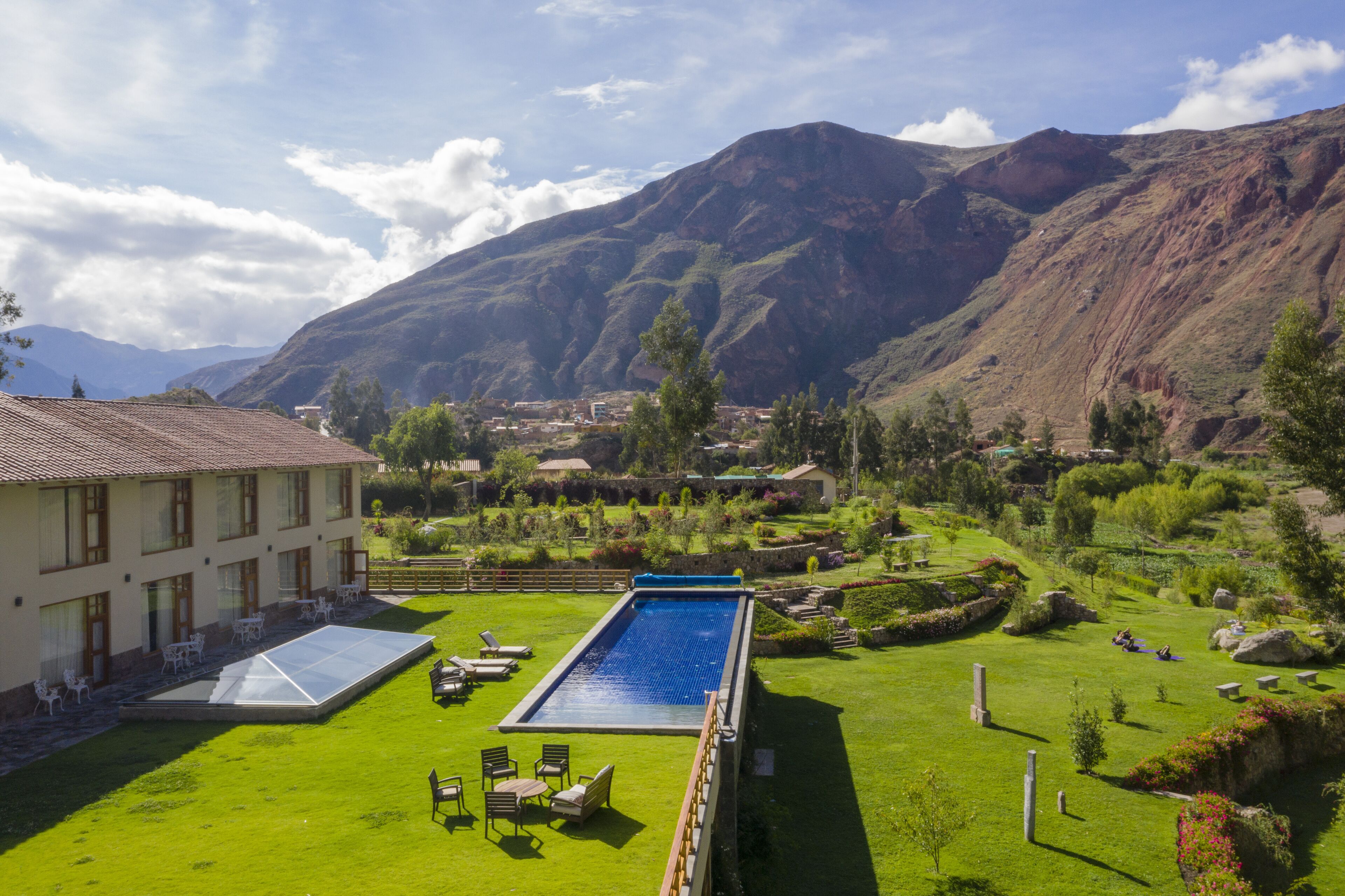 Una piscina al aire libre, sombrillas, sillones reclinables de piscina