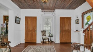 A spacious room with wooden floors, a large rug, and two doors leading to other rooms. - 3/2 Historic Home | Walk to Main | Full Kitchen | WiFi | Hot Tub | Children over 10 welcome! (Fredericksburg)