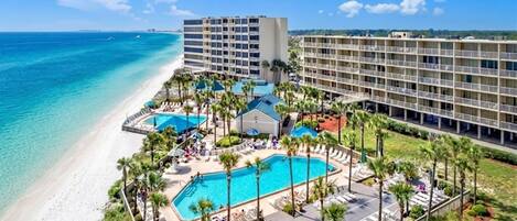 A resort with a pool, beach, and multiple hotel buildings.