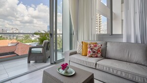 Ein modernes Wohnzimmer mit einer Couch, einem Sessel und einem Couchtisch mit einer Blume.