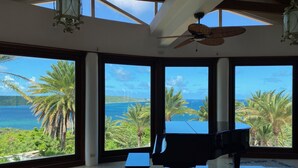 A spacious room with large windows offering a view of the ocean and palm trees. - Sea Views Villa & Guest House with 2 Private Pools. In a Private Club (St. Paul's)