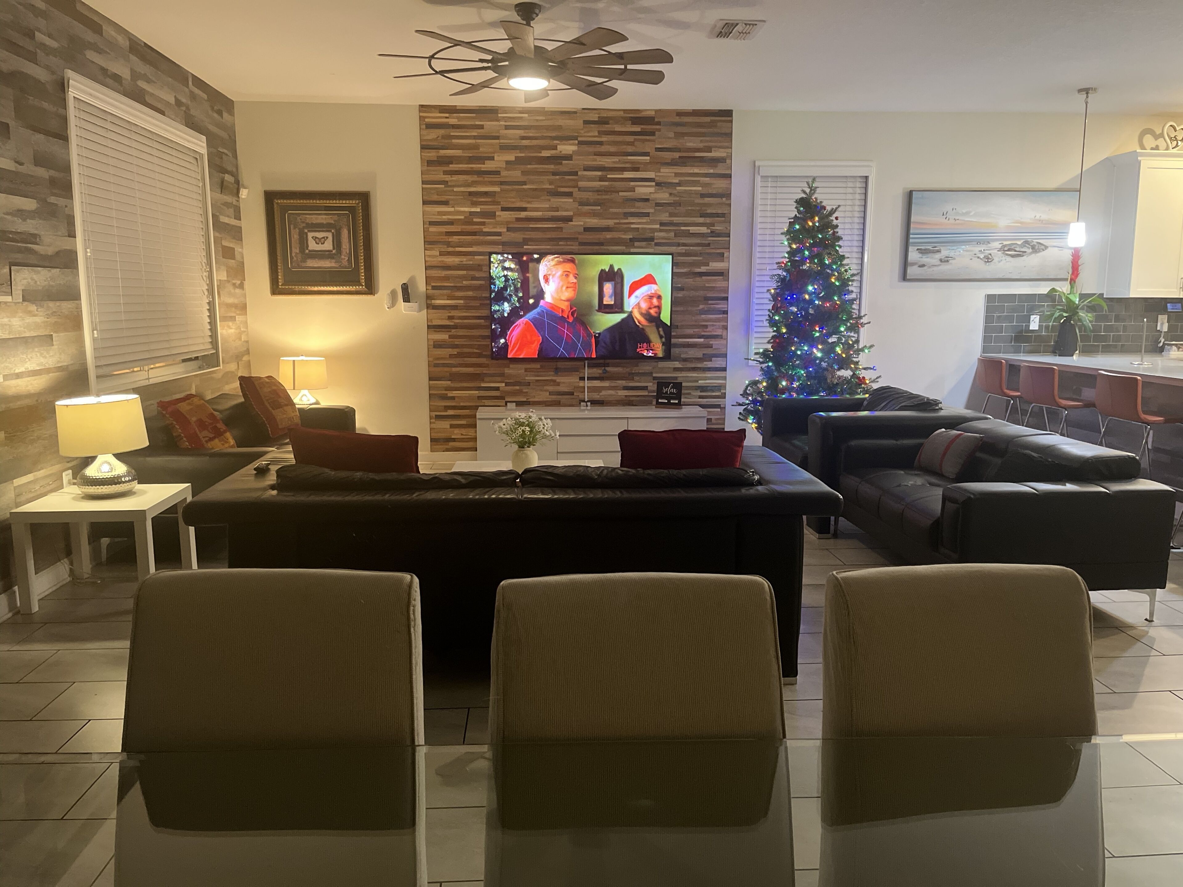 Ein Wohnzimmer mit Fernseher, Weihnachtsbaum und Kamin.