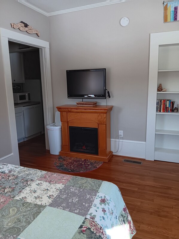 A living room with a fireplace, a television, and a bookshelf.