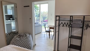 Et soveværelse med en seng, en pudesofa med et mønster, et klædeskab og en balkon med bord og stole.
