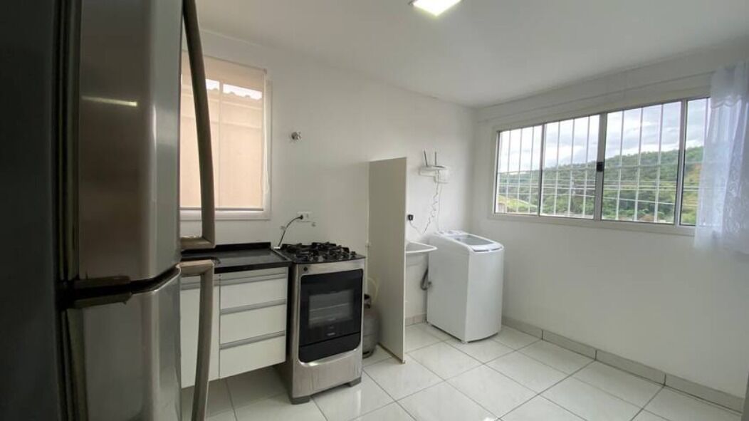 A compact kitchen with a refrigerator, stove, oven, and washing machine.
