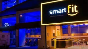 A hotel entrance with a 'smart fit' sign, a reception desk, and a visible staircase.