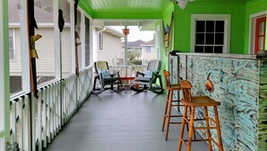 A covered porch with a green ceiling, white railings, and several wooden chairs. - Location Location Location! Classic Beach Cottage less than 1-min walk to beach! (Murrells Inlet)