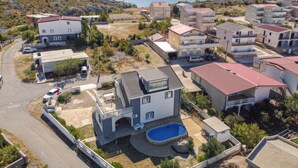 Un barrio residencial con casas modernas, una piscina y vistas al mar.