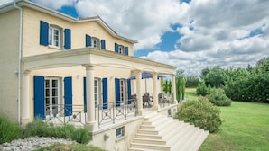 A two-story building with a covered porch and outdoor seating. - Nice villa with private pool and pool house (Montaigu de Quercy)