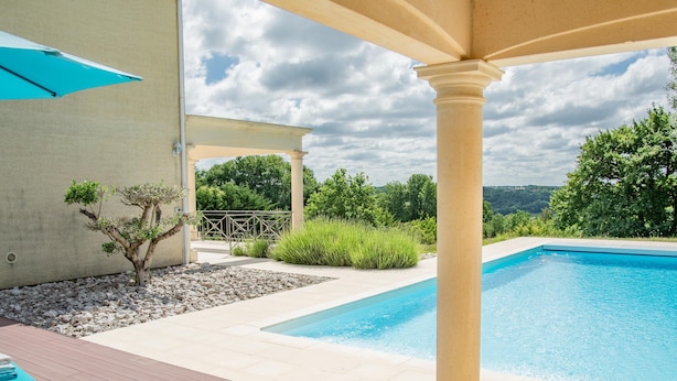 A pool area with a pergola, a small tree, and a view of the landscape. - Nice villa with private pool and pool house (Montaigu de Quercy)
