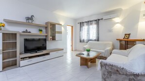 A modern living room with a flat-screen TV, a sofa, a coffee table, and a dining area. - Villa Rosa with mountain views, pool, Wi-Fi, air conditioning, terrace and garden (Benissa)