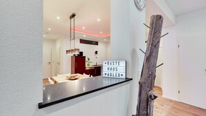 Eine moderne Küche mit schwarzem Arbeitsplatz, einer hängenden Leuchte und einem Schild mit der Aufschrift 'GASTE HAUS ADLER'.