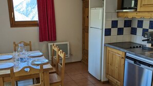 A kitchen with wooden cabinets, a stainless steel dishwasher, a microwave, and a tiled backsplash.