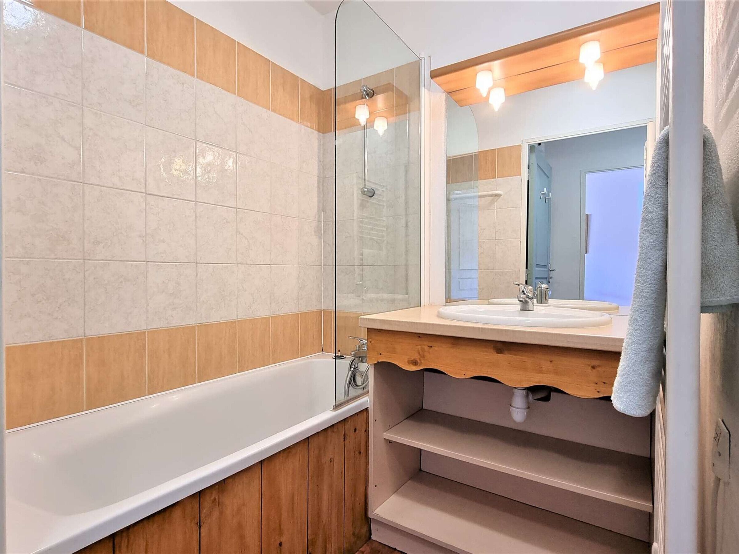 A bathroom with a bathtub, a sink, and a mirror.