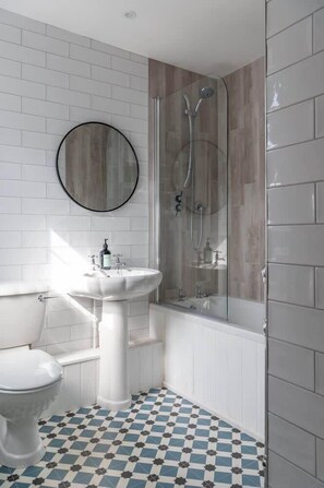 A bathroom with a white sink, toilet, and shower. - Beautiful House in Bideford on Peaceful Street (Bideford)