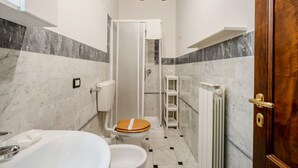 Un baño con ducha, inodoro y lavamanos.