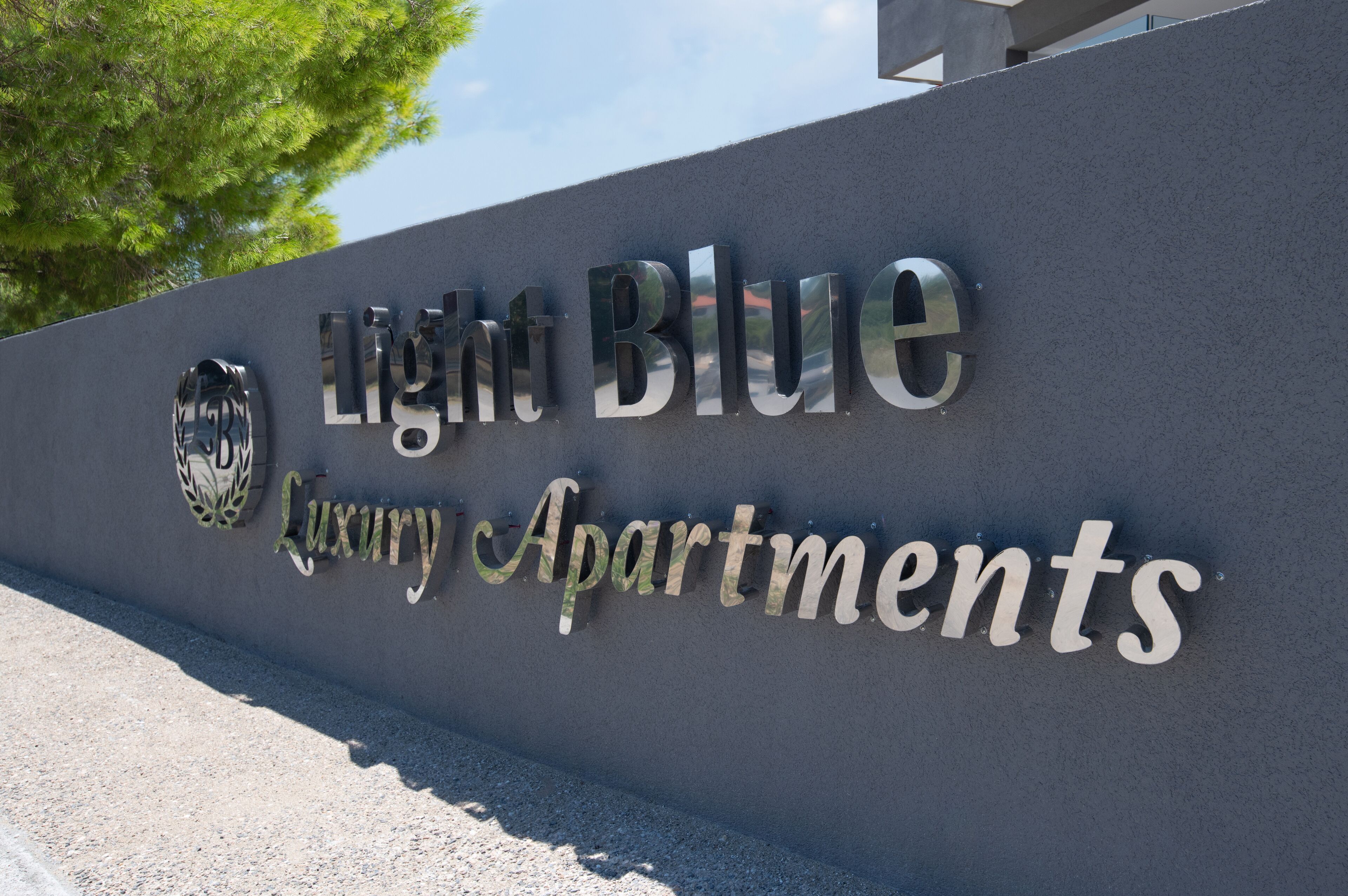 A sign for Light Blue Luxury Apartments with a logo and text.