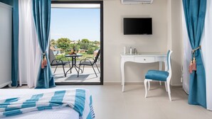 A hotel room with a bed, a desk, a chair, a TV, and a balcony with a view of the outside. - Light Blue Luxury Rooms (Nea Propontida)