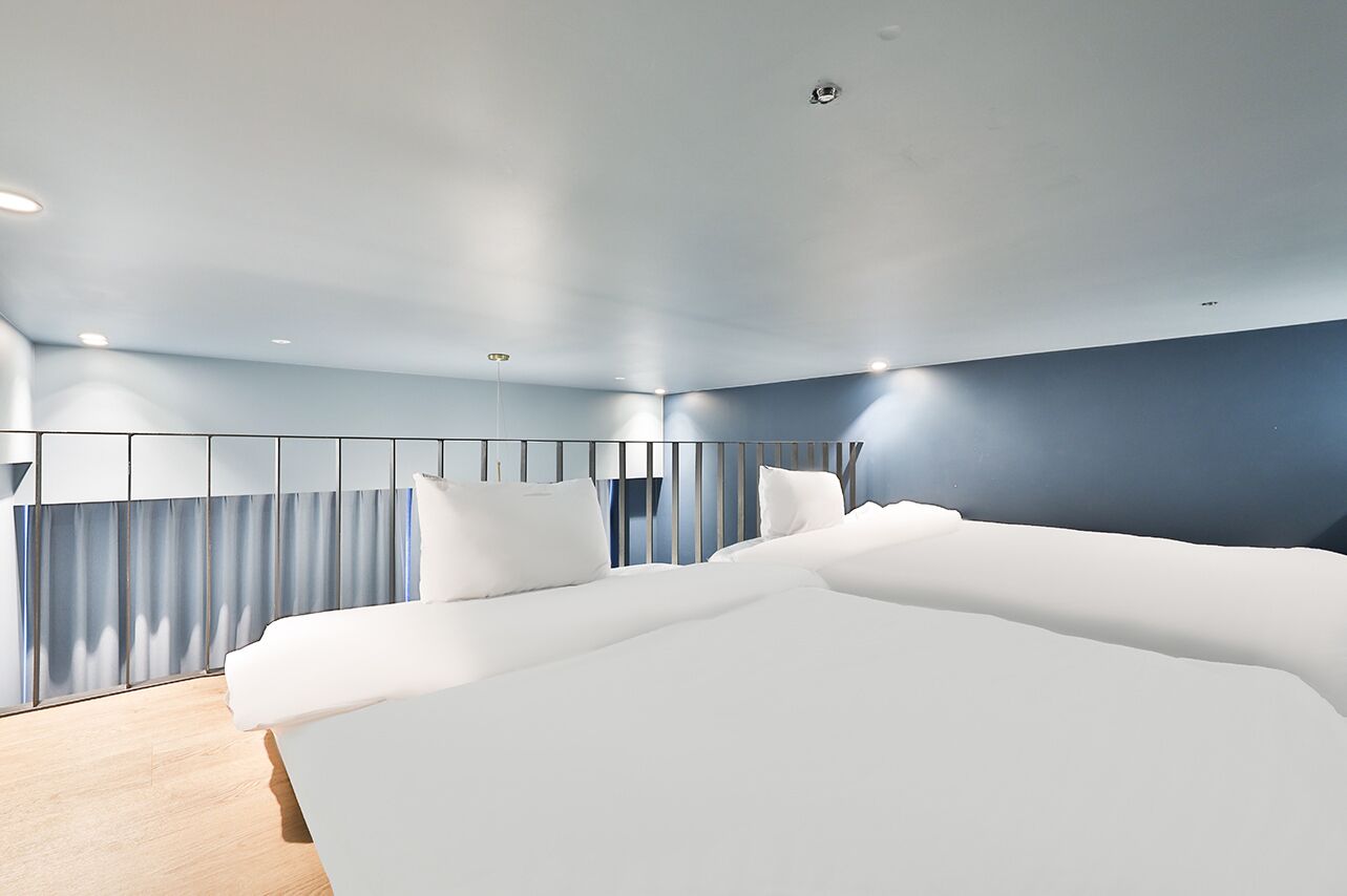 Ett modernt hotellrum med en stor säng, ett skrivbord och utsikt över staden.