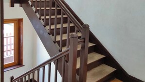 A wooden staircase with a handrail and a window at the bottom landing. - Apartment with a view in the center of Bussang (Bussang)