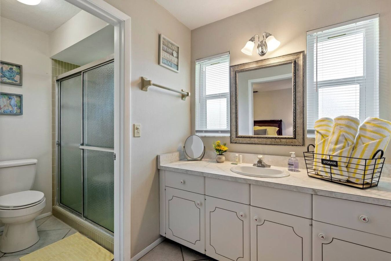 Une salle de bain équipée d’une douche, de toilettes, d’un meuble-lavabo avec un miroir et d’un porte-serviettes.