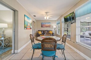 A dining area with a round table, four chairs, and a ceiling fan. - Cottage w/lanai and garage, 4 mi. Siesta Key (Sarasota)