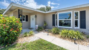A modern two-story house with a front porch, a mailbox, and a well-maintained garden. - Sarasota Getaway Near Siesta Key, Screened Lanai + Garage, Pet Friendly (Sarasota)