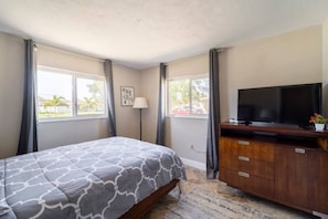 A bedroom with a bed, a TV, a dresser, and a window with curtains. - Cottage w/lanai and garage, 4 mi. Siesta Key (Sarasota)