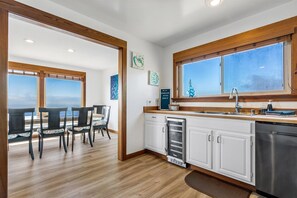 Una cocina moderna con armarios blancos, un lavamanos de acero inoxidable y una ventana con vistas.