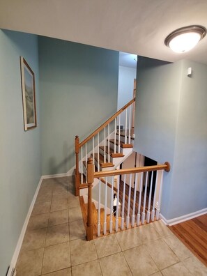 A staircase with wooden handrails and white balusters, leading to an upper floor. - Andrea Abode 5 Bedroom Home by RedAwning (Lexington)