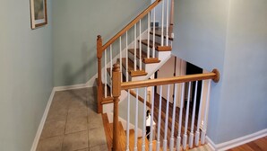 Un escalier avec des rampes en bois et des carreaux de couleur beige.