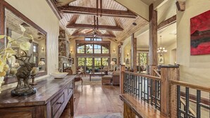 Ein geräumiger Innenraum mit hohen Decken, Holzbalken und großen Fenstern.
