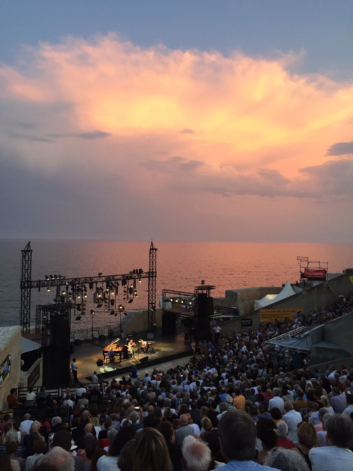 A concert stage with a crowd of people in the foreground.