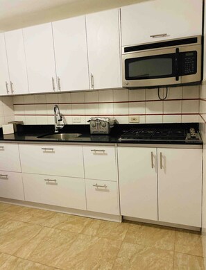 Fridge, microwave, coffee/tea maker, cookware/dishes/utensils