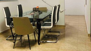 A conference room with a glass table, six chairs, a flat-screen TV mounted on the wall, and a painting on the wall. - New Beautiful 2 bedroom full Apartment San Juan, Area Metro. (San Juan)