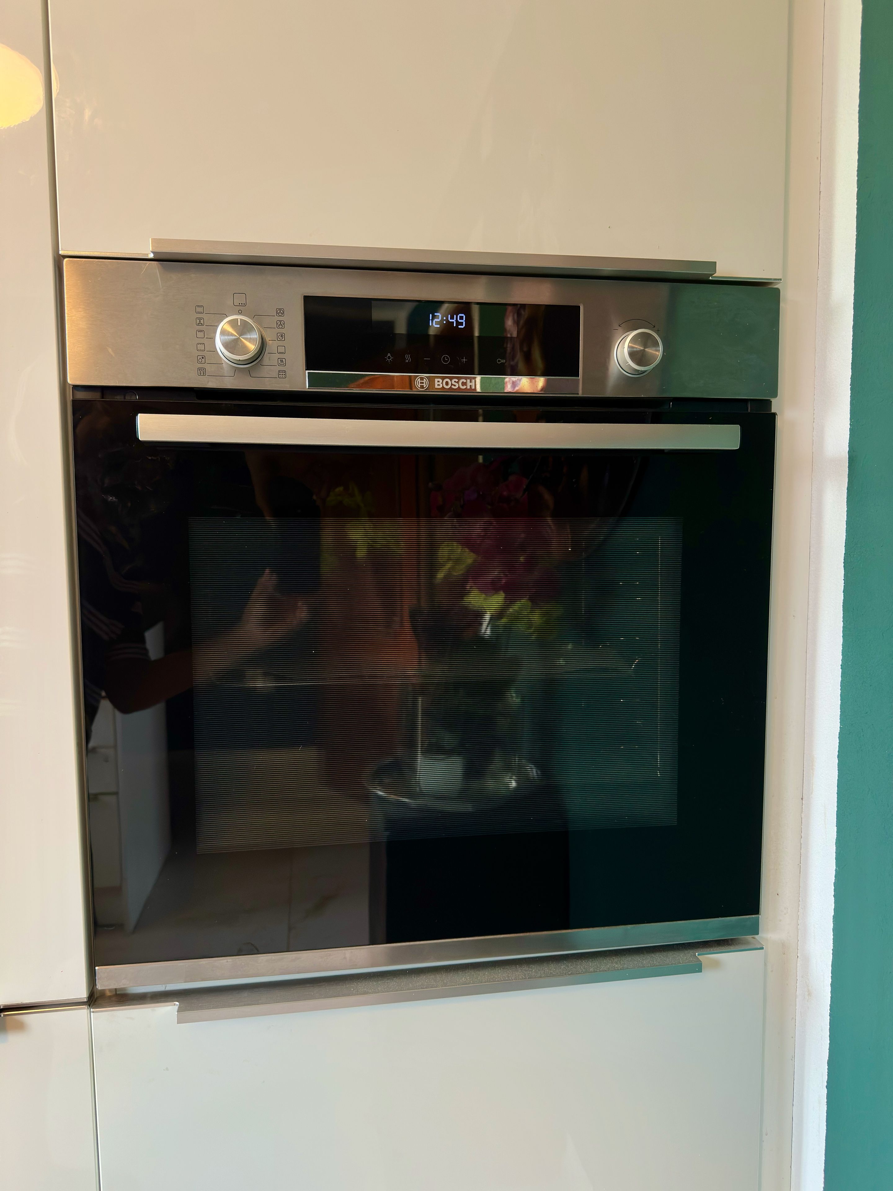 Ein Backofen von Bosch mit digitaler Uhr, die 12:49 anzeigt.