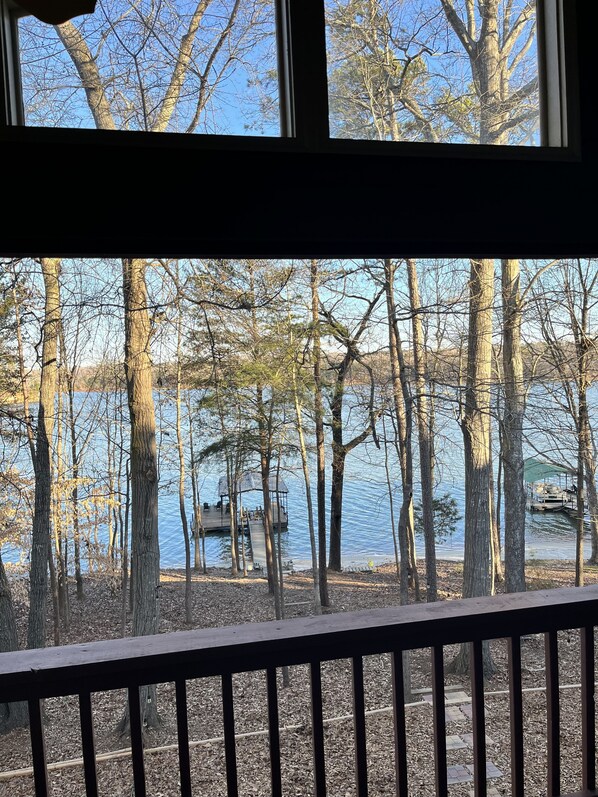 A view of a lake surrounded by trees, a dock, and a gazebo.