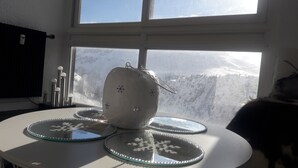 Une table ornée d’un objet décoratif et de deux assiettes en verre décorées de motifs en forme de flocons de neige.