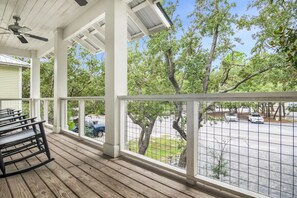 Enjoy the serene view from this covered porch, overlooking the parking lot and surrounding trees.