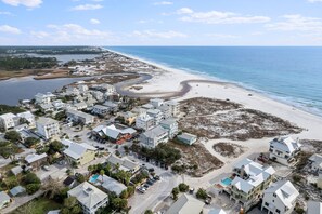 Stunning coastal community with modern and traditional homes, situated near a sandy beach and body of water.