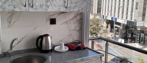Una cucina moderna con mobili in marmo, una lavatrice Bosch e una macchina da caffè.